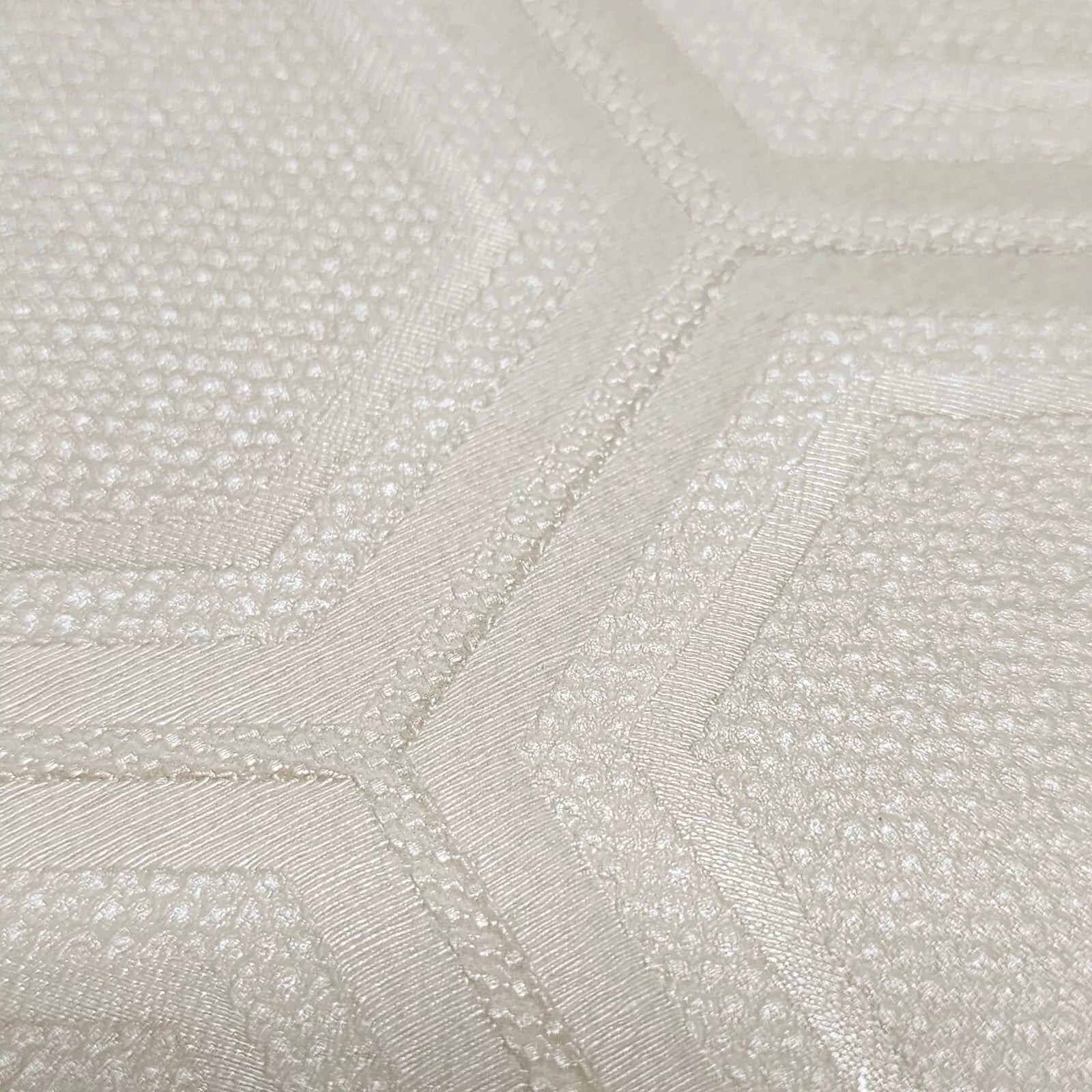 Close-up of textured cream wallpaper with a subtle pattern