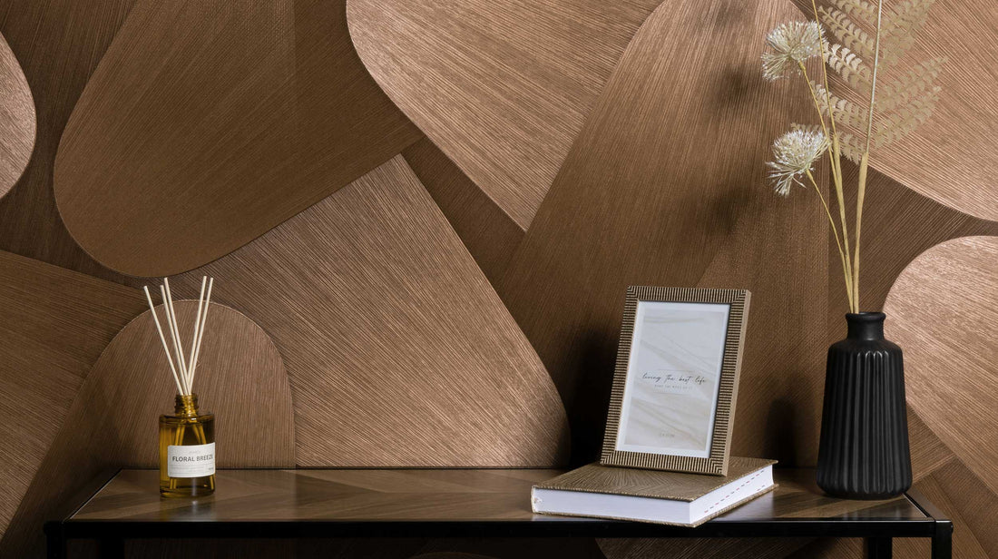 Erismann Elysium abstract geometric wallpaper with layered curved shapes in deep brown and warm bronze tones, featuring a textured finish for bold contemporary interiors.